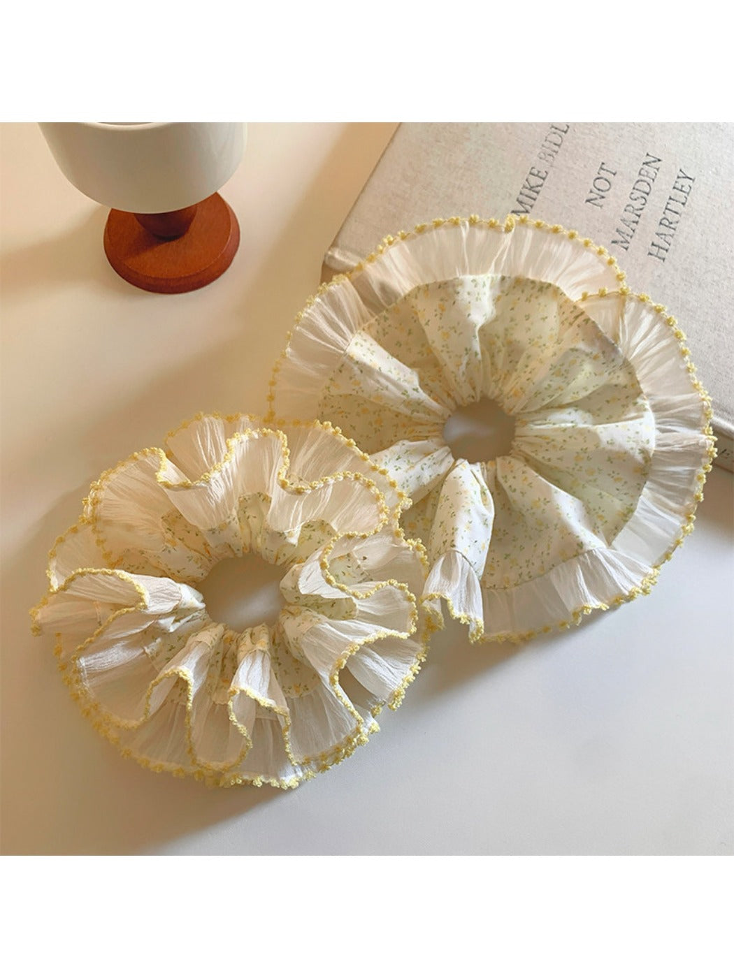 Yellow pleated scrunchie with floral print on white background