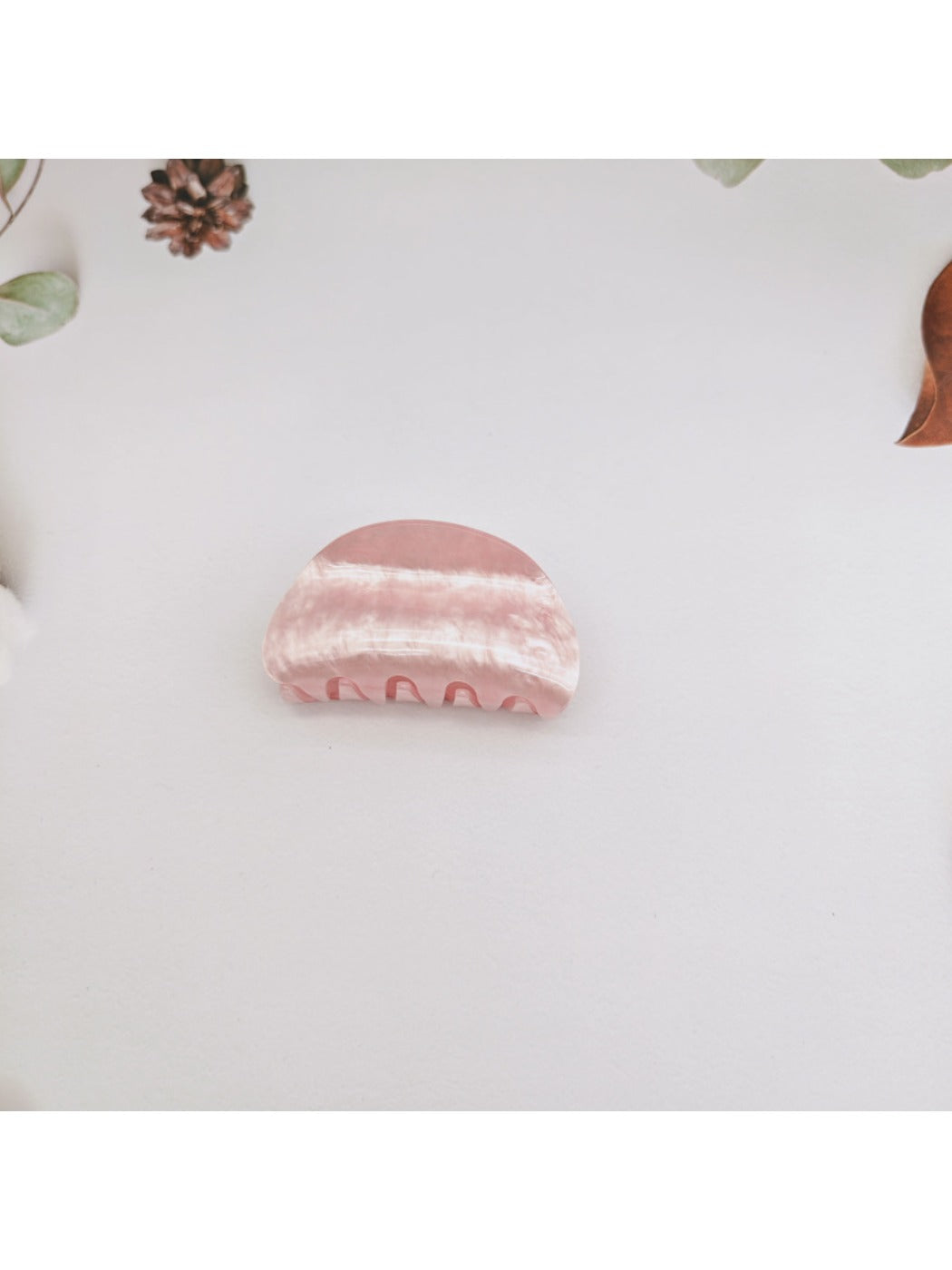 Beau claw clip placed on a wooden surface emphasizing marble design