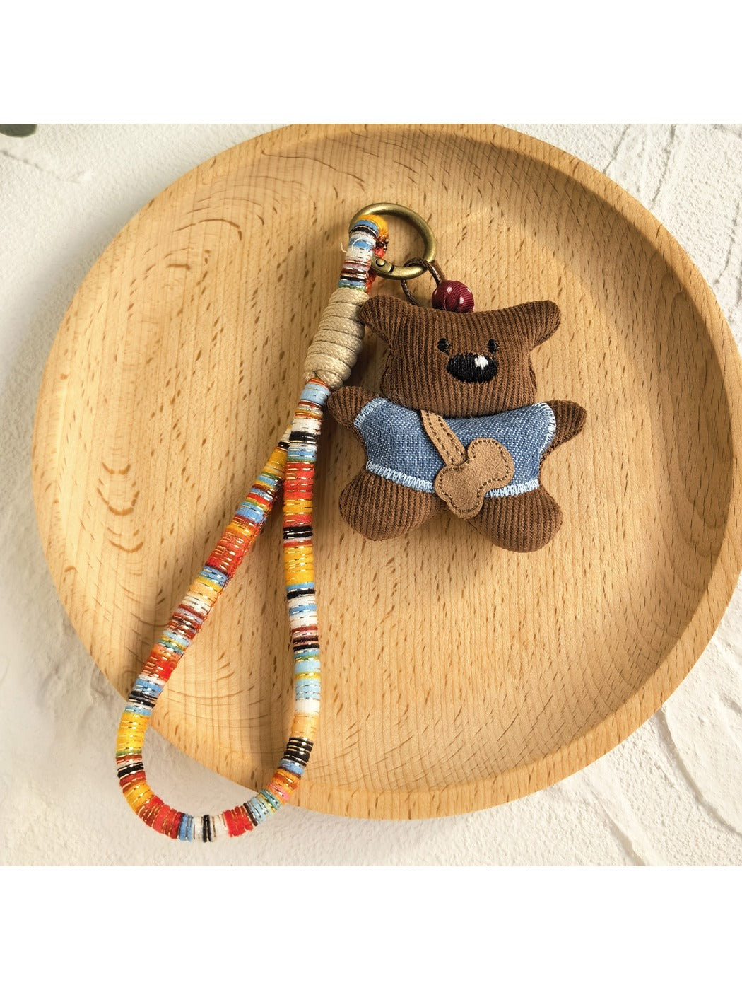 Keypus fabric doll keychain hanging from a purse handle