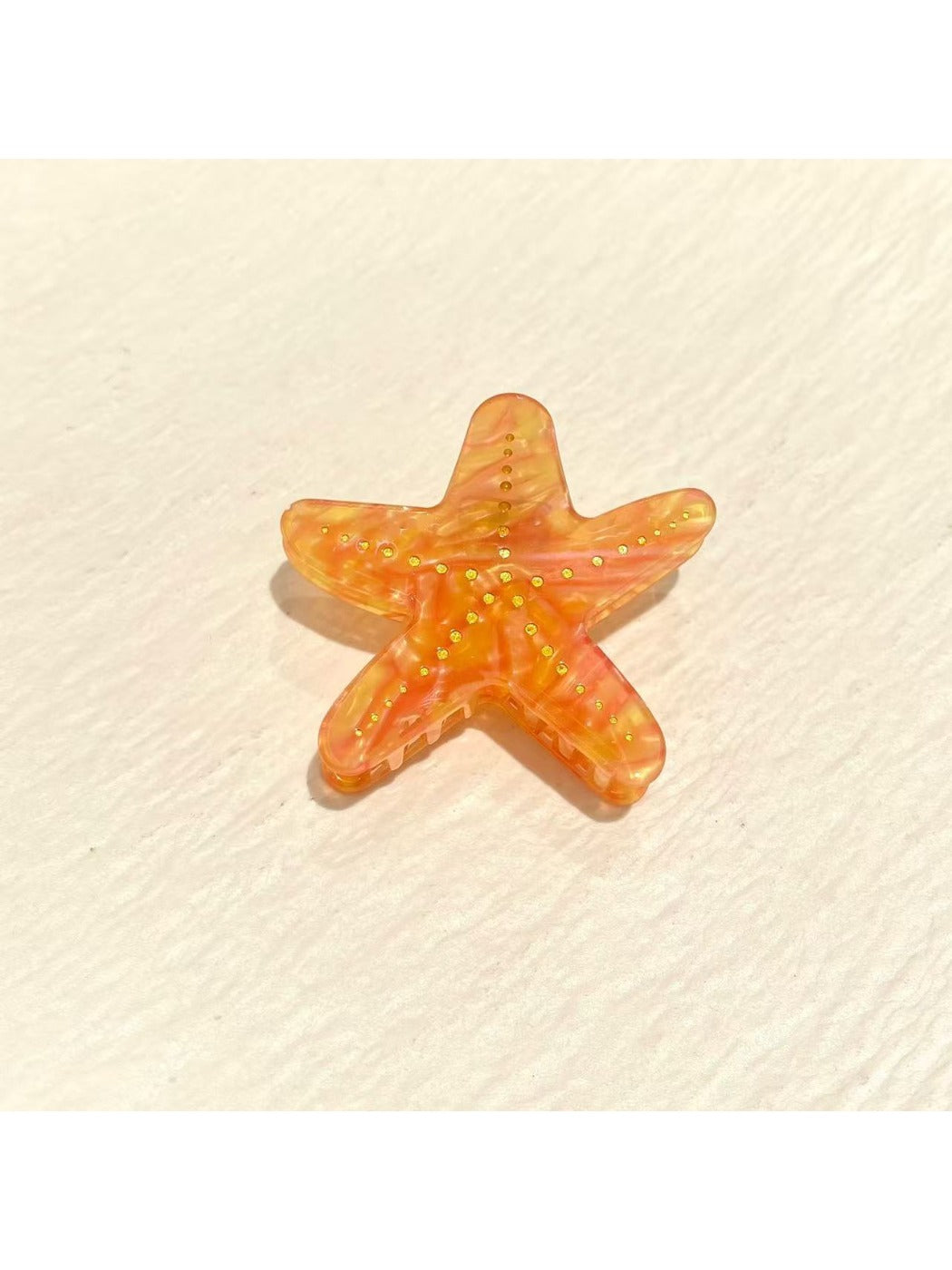 Beau claw clip styled in hair holding a section of blonde hair
