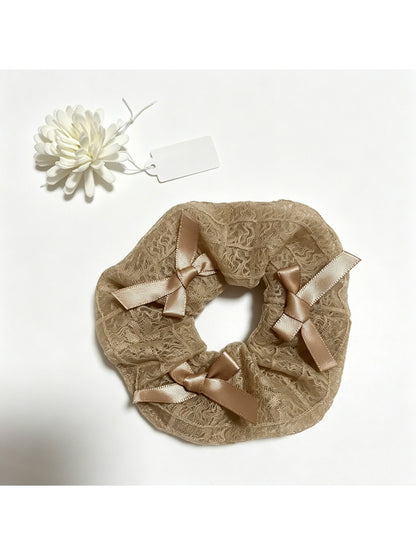 Gifty satin bow lace scrunchie styled with casual outfit on a wooden surface