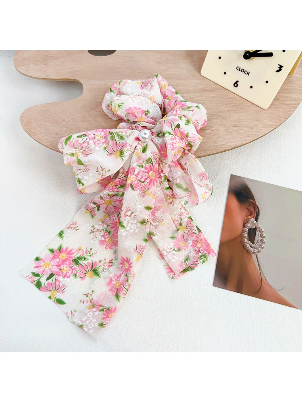 Gifty scrunchie styled in hair, emphasizing floral print and ruffled bow detail