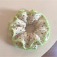 Close-up of Gifty Sweet Polka Dot Ruffled Scrunchie in pink with white dots
