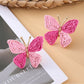 Close-up of butterfly earring detail showing smooth metal finish