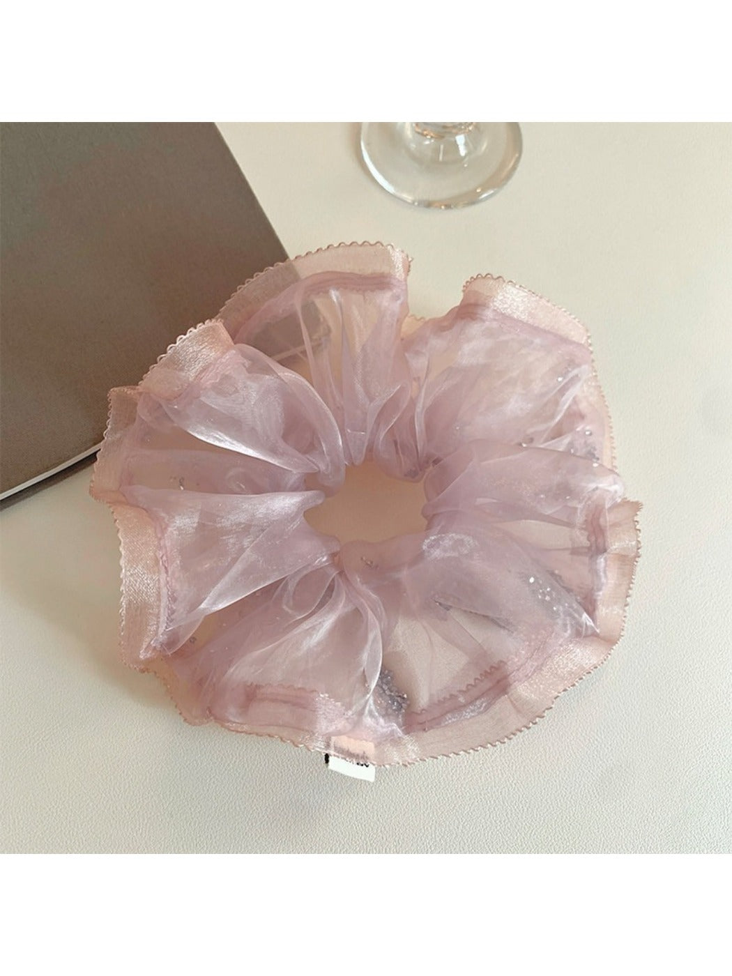 Model wearing the pink ruffled scrunchie in a ponytail hairstyle