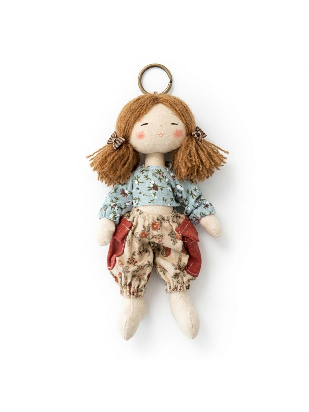 Fabric yarn doll keychain attached to a backpack zipper pull