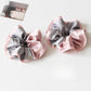 Gifty scrunchie displayed on a white background highlighting its shape and colors