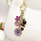 Daisy charm keychain attached to a set of keys on a wooden surface