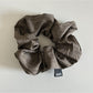 Vintage pleated fabric scrunchie packaged in clear plastic bag with branding