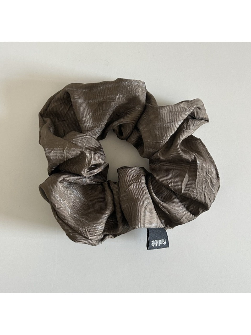 Vintage pleated fabric scrunchie packaged in clear plastic bag with branding