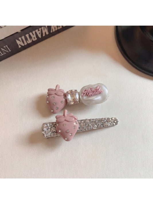 Beau hair clip worn in blonde hair showing the strawberry detail and gold clip base