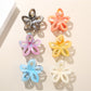 Beau colorful flower-shaped hair clip with openwork design on white background