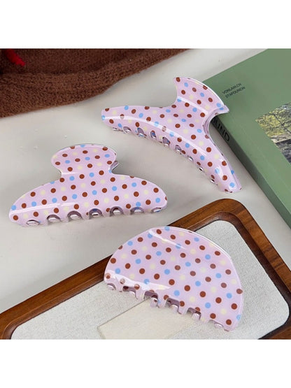Beau pink polka dot claw clip held in hand showing size and crescent shape