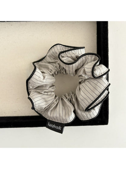 Gifty scrunchie held in hand showing size and stretchiness of fabric