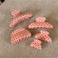 Side view of Beau polka dot claw clip displaying curved teeth