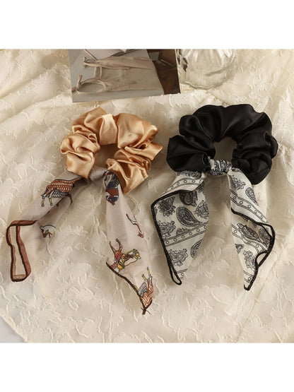Close-up of vintage satin bow hair scrunchie in soft pink on white background