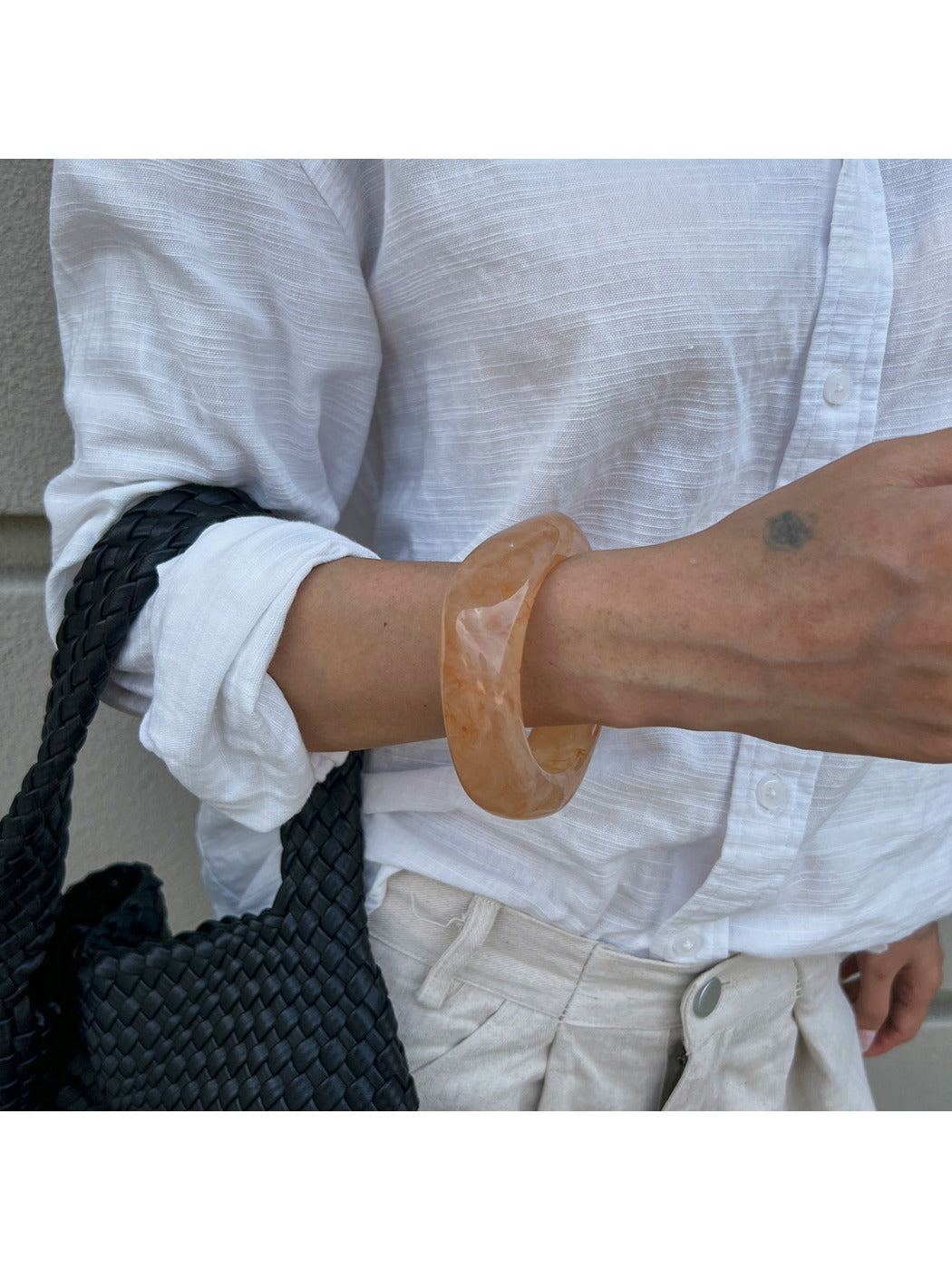 Detailed shot of Lovra bracelet's smooth metal surface and irregular shape