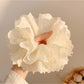 White fluffy scrunchie styled on a wrist as a fashion accessory