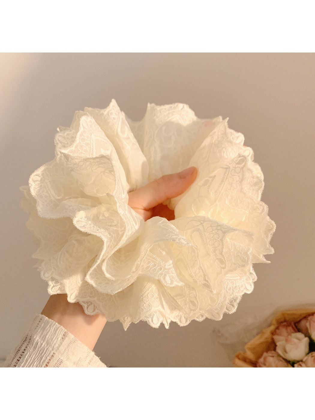 White fluffy scrunchie styled on a wrist as a fashion accessory