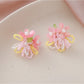 Earedge small beaded earrings with multicolor flower design held in hand