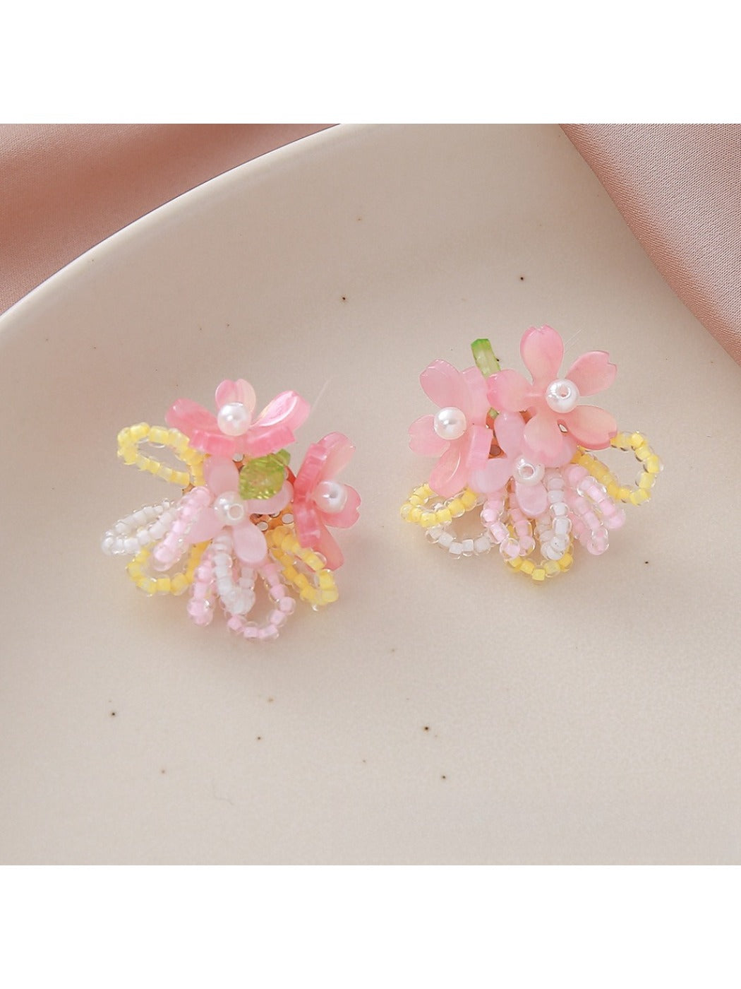 Earedge small beaded earrings with multicolor flower design held in hand
