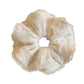 Beige ruffle scrunchie displayed on a white background