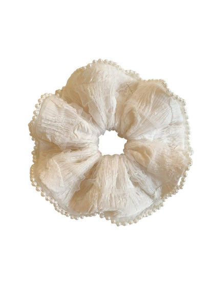 Beige ruffle scrunchie displayed on a white background