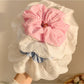 Close-up of ruffled plaid fabric on large scrunchie showing texture