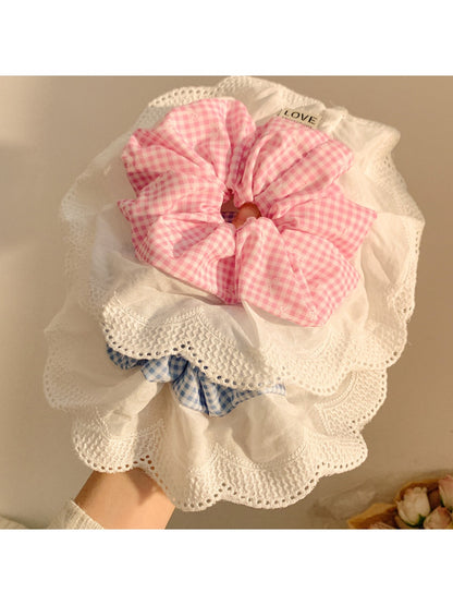 Close-up of ruffled plaid fabric on large scrunchie showing texture