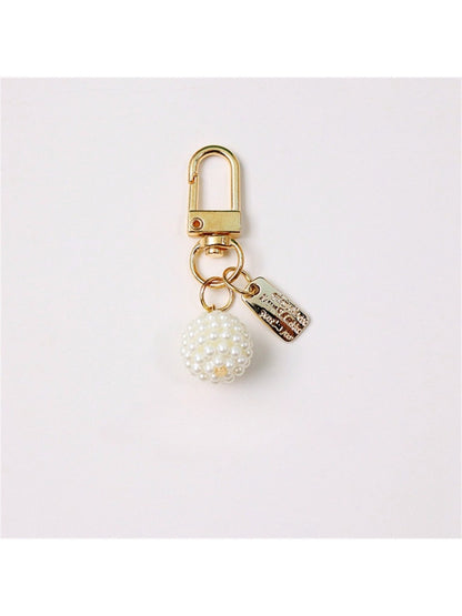 Hand holding Keypus beaded bow charm keychain showing size and detail of beads and bow