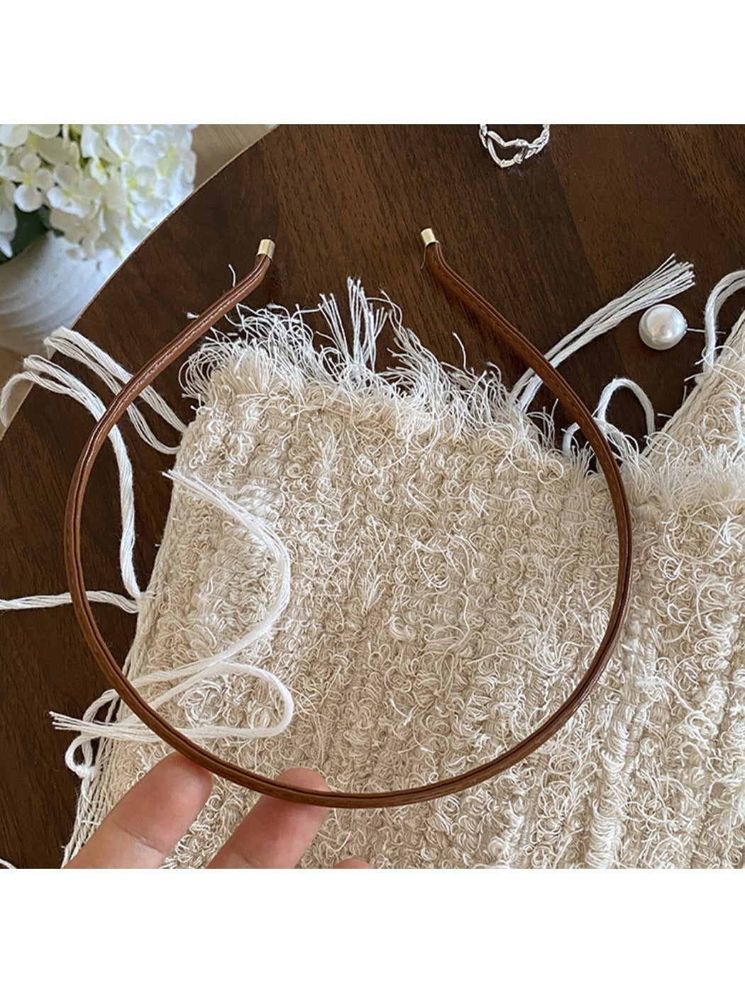 Gifty headband in soft beige color folded to show flexibility and fabric quality