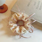 Close-up of Gifty scrunchie showing detailed bow pattern