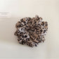 Leopard print scrunchie stretched to show elastic band inside