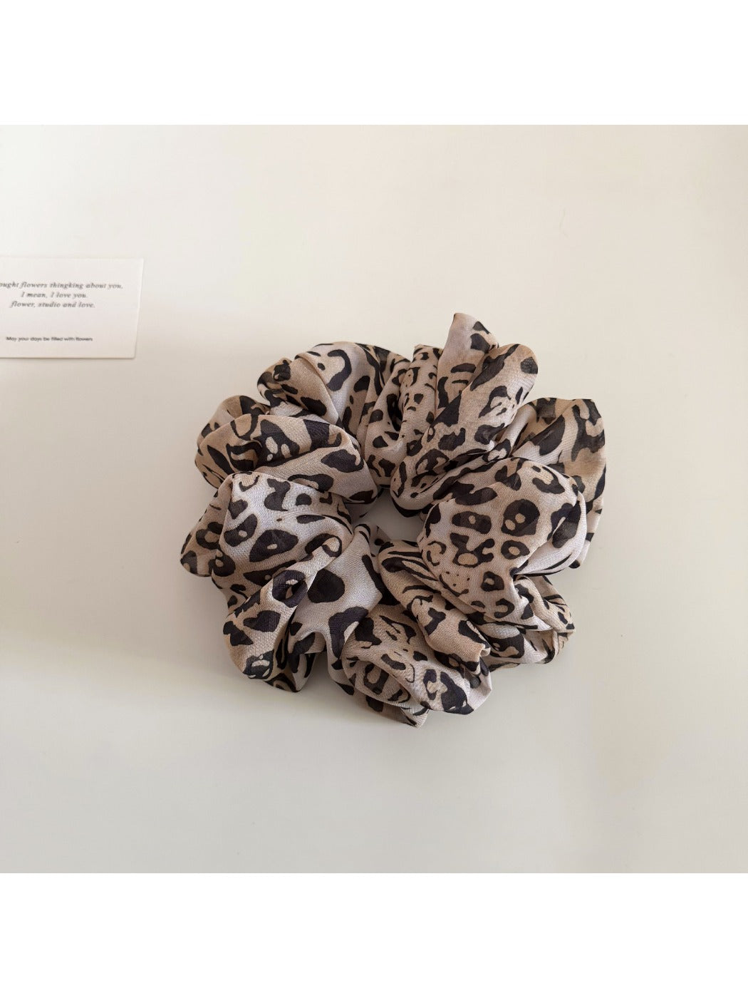 Leopard print scrunchie stretched to show elastic band inside