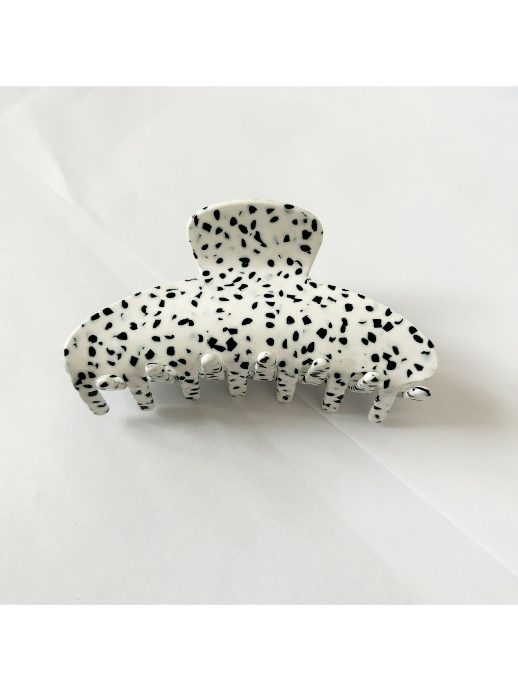 Beau floral acetate claw clip placed on wooden surface with natural light
