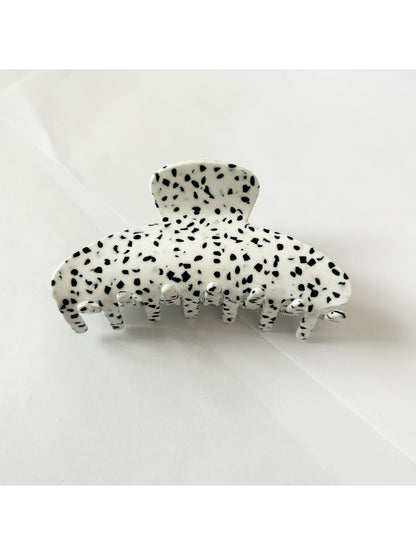 Beau floral acetate claw clip placed on wooden surface with natural light