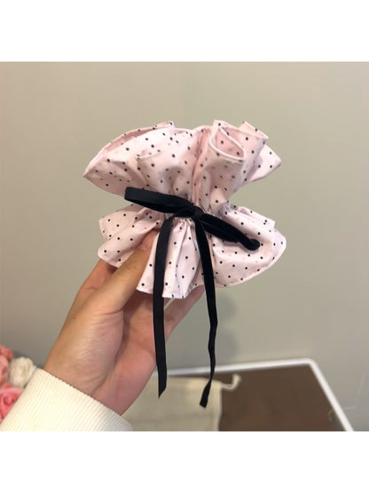 Gifty sweet polka dot bow scrunchie held in hand showing size and shape