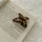 Beau butterfly claw clip held in hand to show size and scale