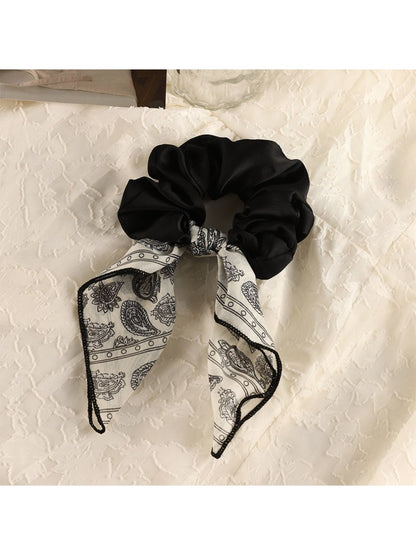 Top view of vintage satin bow hair scrunchie showing smooth fabric texture