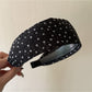 Gifty headband styled on a mannequin with tiny floral design