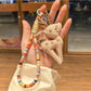 Hand holding the stylish deer charm keychain with natural lighting