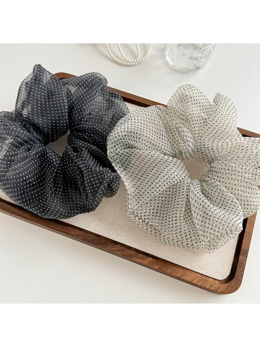 Close-up of pink tulle scrunchie showing delicate polka dot pattern and texture
