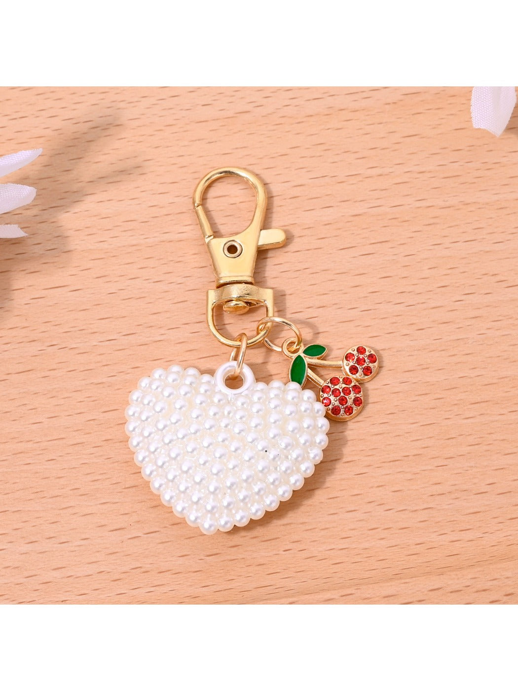 Close-up of gold clasp on red heart shaped bag charm keychain