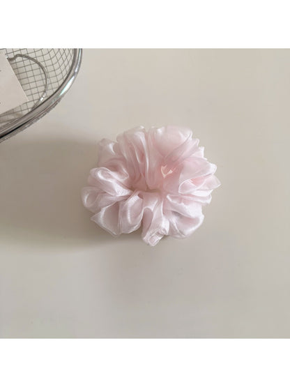 Model holding a minimalist solid color scrunchie in hand