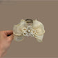 Beau bow shaped hair claw clip in soft pink color on white background