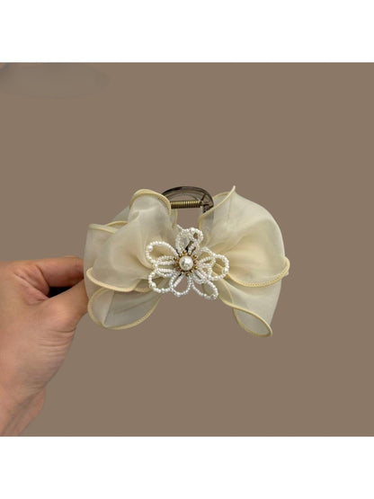 Beau bow shaped hair claw clip in soft pink color on white background