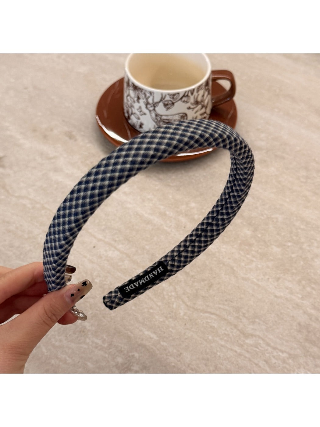 Model adjusting Gifty plaid headband while looking sideways