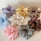 Soft pink scrunchie with a delicate floral pattern on a white background