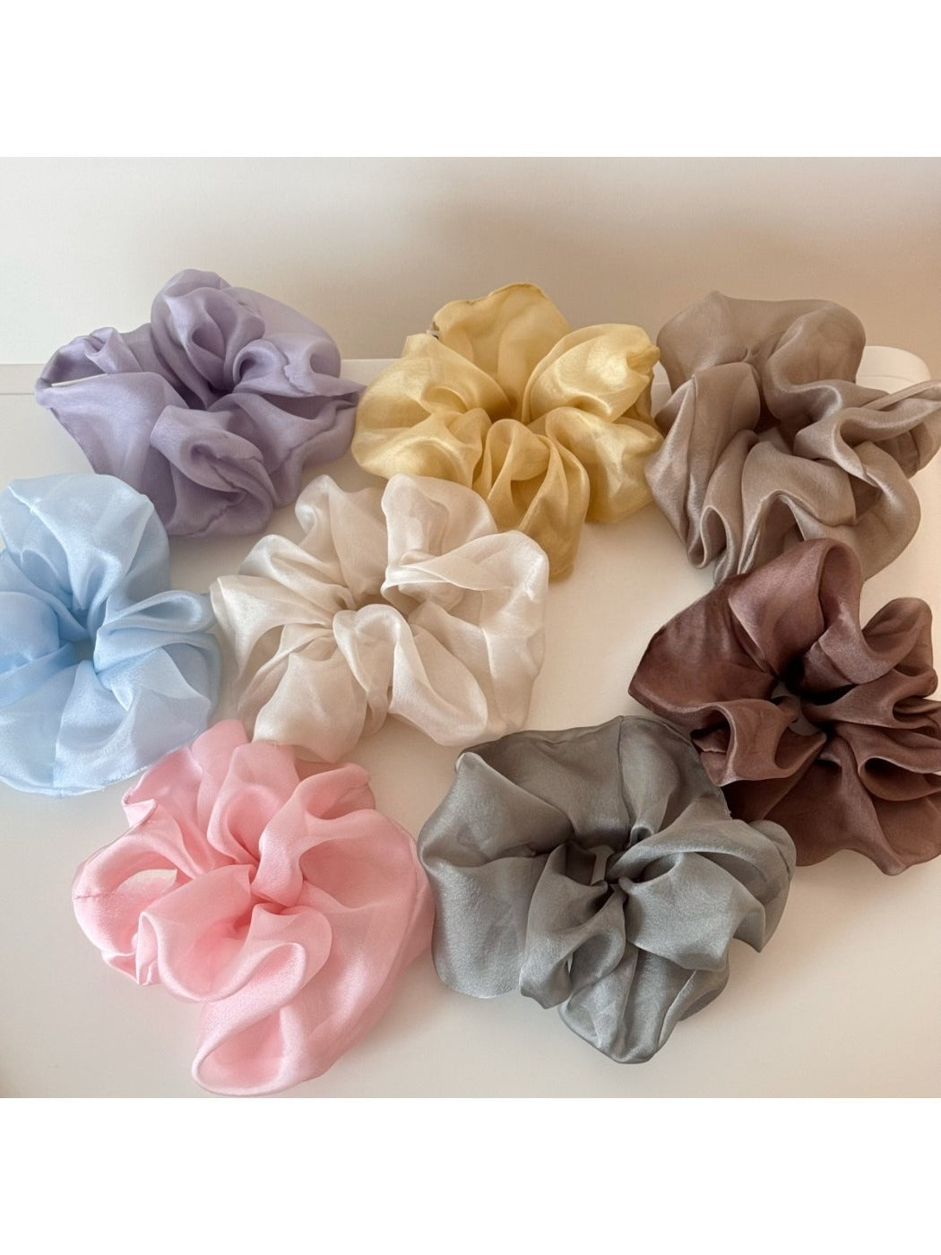 Soft pink scrunchie with a delicate floral pattern on a white background