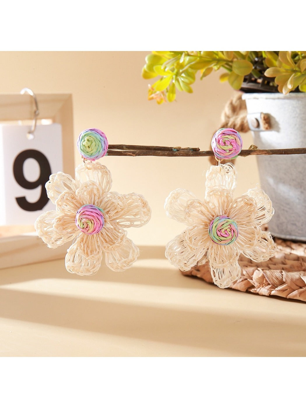 Side view of raffia flower shaped drop earrings showing detailed weaving